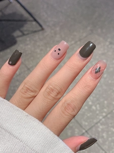 Detail of dark grey argyle and pink nail stickers with black polka dots on nails