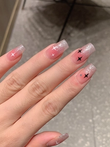Detail of pink gradient press-on nails with silver glitter and black white star patterns