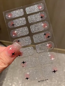 Detail view of silver glitter gradient nail stickers with star patterns applied on nails