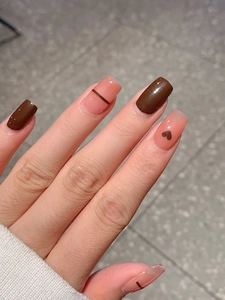 Detail of glossy brown and pink nail stickers with dark heart and stripe patterns