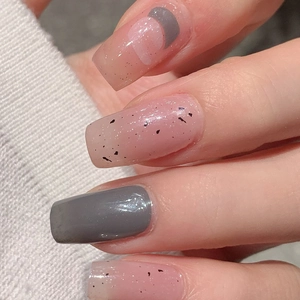 Short square press-on nails with grey and pink marble patterns on knit background