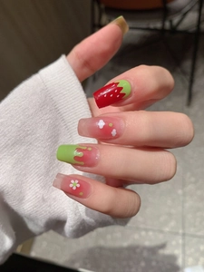 Detailed view of sweet strawberry themed press-on nails with floral and drip glue art