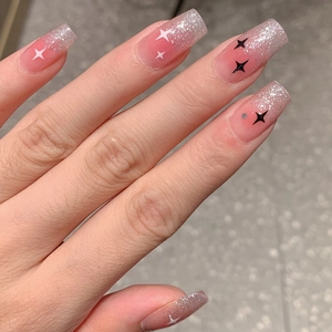 Pink gradient press-on nails with silver glitter tips and black white star patterns