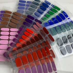 Macro shot of colorful 14-piece nail sticker sets in various shades and sizes on white base