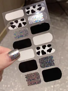 Détail de stickers à ongles motif vache et monochrome avec effet pailleté holographique
