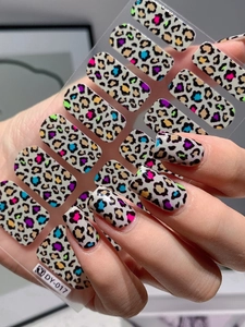 Macro shot of colorful marble leopard print nail stickers showing realistic hand application