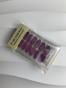 Close-up of a 14-piece set of solid purple glossy nail stickers in retail packaging