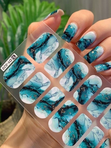 Detail of blue-green marble ink nail stickers with gold glitter and self-adhesive finish