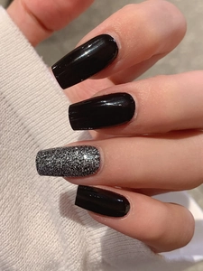 Gros plan d'ongles adhésifs noirs brillants et pailletés argent de forme trapèze