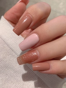 Close-up of nude pink and mocha nail stickers with silver glitter on long square nails