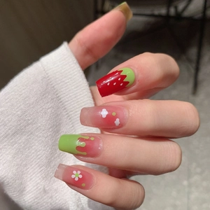 Long coffin strawberry press-on nails with floral patterns and vibrant red finish