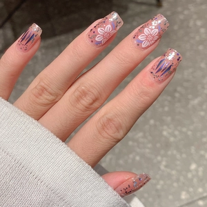 Faux ongles dégradés français avec motifs floraux, paillettes et fleurs peintes