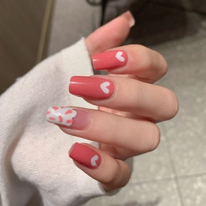 Pink heart and cow print pattern square press-on nails shown on a hand model