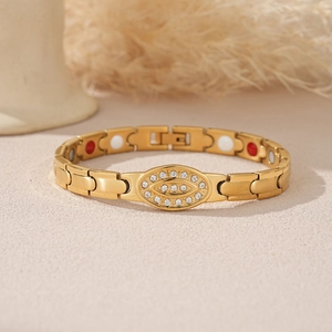 Detailed macro view of gold-plated stainless steel magnetic bracelet with evil eye charm
