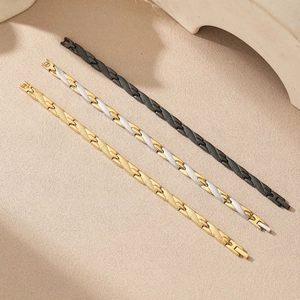 Minimalist dragon pattern magnetic bracelets in black and gold on a textured surface