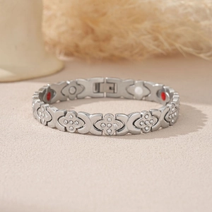 Détail macro du bracelet trèfle en acier inoxydable argenté avec zircons et aimants