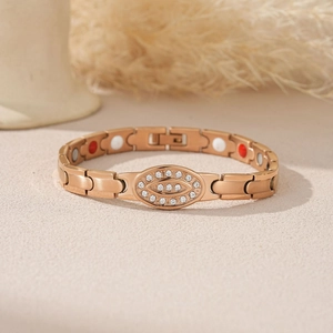 Detail of rose gold magnetic bracelet with rhinestones and therapeutic stones