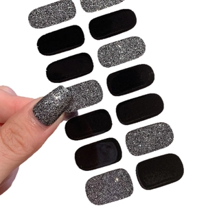 Autocollants à ongles noir et paillettes argent avec démonstration sur fond blanc neutre