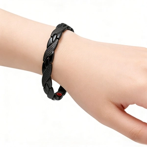 Detail of black magnetic therapy bracelet with dragon scale texture on a wrist