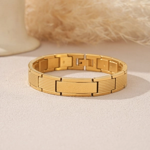 Detail eines goldenen Edelstahl-Kettenarmbands mit polierter, gravierbarer Metallplatte