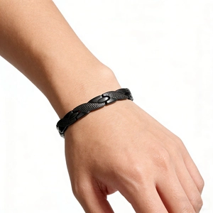 Detail of black magnetic dragon texture bracelet on wrist featuring scale pattern links