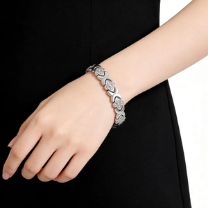 Gros plan d'un bracelet magnétique trèfle argenté avec diamants sur le poignet d'un mannequin