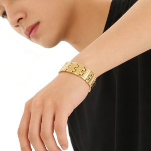 Bracelet minimaliste en acier inoxydable doré pour homme porté par un mannequin