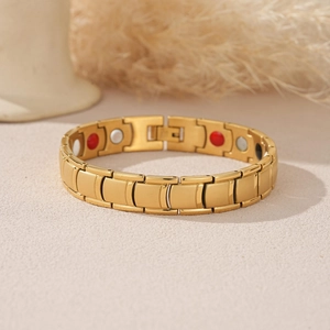 Gold stainless steel magnetic therapy bracelet for men with matte finish on beige surface
