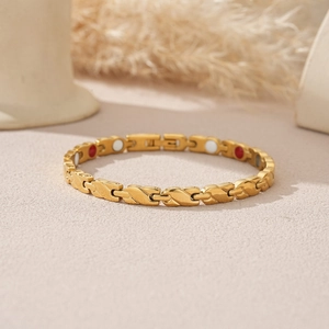 Macro-opname van gouden magnetische armband met S-vormige schakels en functionele stenen