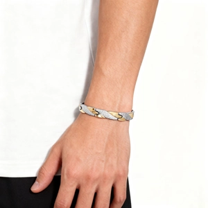 Detail of men's two-tone magnetic bracelet with silver dragon scale texture and gold links