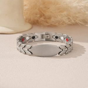Macro shot of steel magnetic link bracelet featuring grain pattern and engravable plate