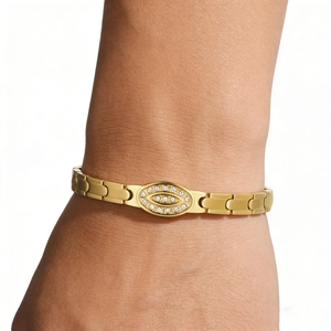 Close-up of gold chain bracelet with oval cubic zirconia centerpiece on a wrist