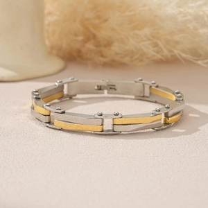 Vue macro d'un bracelet industriel bicolore avec des maillons en métal argenté et doré