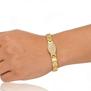 Close-up of gold stainless steel bracelet with oval diamond-encrusted centerpiece on wrist