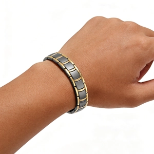 Detail of two-tone men's steel link bracelet in gunmetal grey and polished gold finish