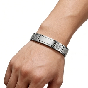 Detail eines verstellbaren Edelstahl-Herrenarmbands mit texturierten Gliedern am Handgelenk