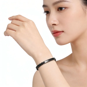 Gros plan d'un bracelet en acier inoxydable noir avec barre centrale et zircon au poignet