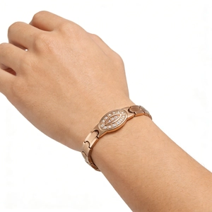 Macro view of rose gold bracelet with crystal-paved oval centerpiece on a female wrist