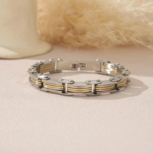 Macro shot of men's industrial stainless steel link bracelet with gold rivet details