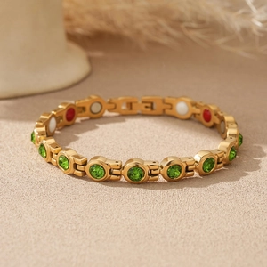 Détail du bracelet à maillons dorés avec zircons verts et inserts magnétiques de santé