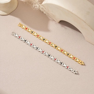 Detail of fishtail magnetic health bracelets in gold and silver on stone texture