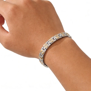 Detail of two-tone stainless steel magnetic bracelet with golden geometric patterns