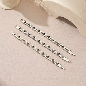 Three men's layered stainless steel link bracelets in silver and gold industrial design