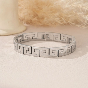 Detailed view of silver stainless steel bracelet featuring intricate Greek key patterns