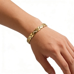 Goldenes Edelstahl-Blattarmband mit weißen Zirkonia-Steinen auf weiblichem Handgelenk