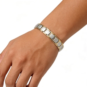 Detail view of two-tone stainless steel magnetic link bracelet worn on a wrist