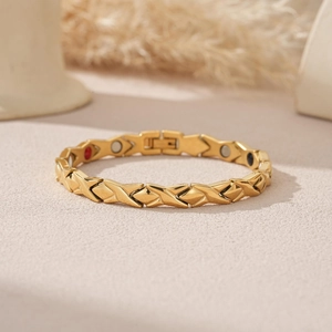 Détail du bracelet magnétique doré avec maillons en X et pierres de soin intégrées