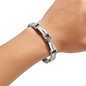 Détail d'un bracelet gourmette argenté aux maillons géométriques polis et brillants