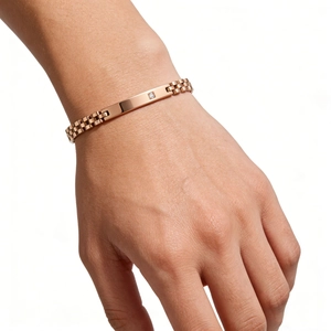 Détail du bracelet en acier inoxydable or rose avec un seul diamant sur une barre