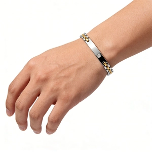 Détail d'un bracelet à maillons en acier de 6 mm avec plaque dorée sertie d'un diamant